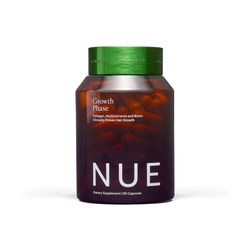 The Nue Co Growth Phase bottle on a vanity suggesting a fuller-looking hair routine