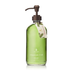 Thymes Frasier Fir hand wash bottle on sink with elegant glass packaging.