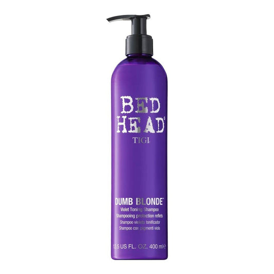 TIGI Bed Head Dumb Blonde purple toning shampoo bottle pouring for even toning and refreshment.