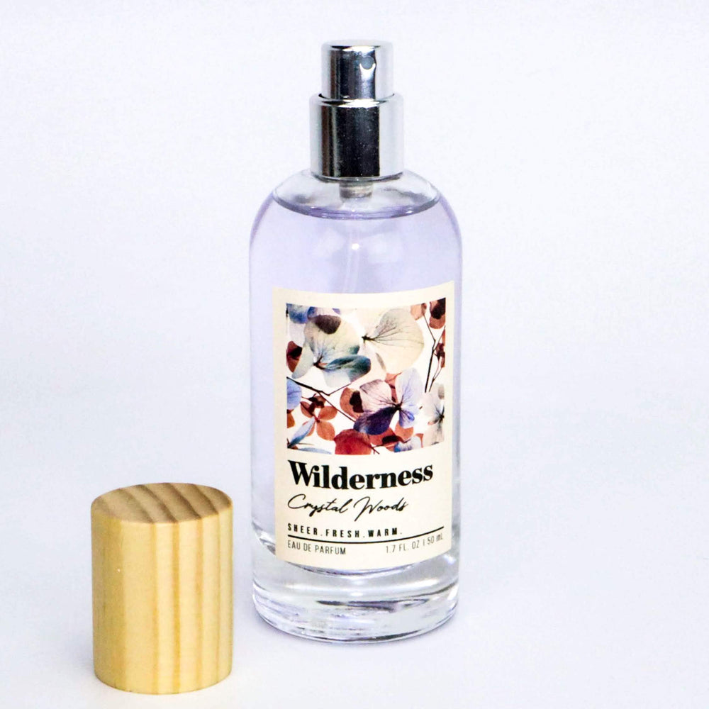 Tru Fragrance Beauty Wilderness Crystal Woods EDP bottle on wood surface evoking nature-inspired scent