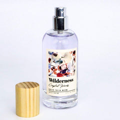 Tru Fragrance Beauty Wilderness Crystal Woods EDP bottle on wood surface evoking nature-inspired scent