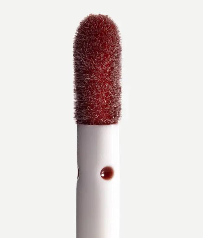Typology lip oil swatch on lips showing a glossy, non-sticky finish
