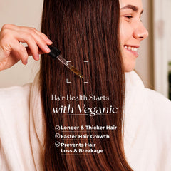 Veganic Hair Growth Oil dropper releasing a precise amount for easy application.