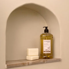 A LA MAISON Oat Milk Body Wash bottle side profile shows compact packaging.