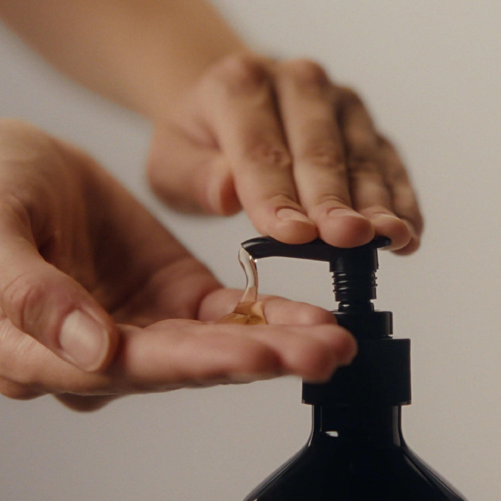 Aesop Coriander Seed Body Cleanser bottle on sink highlighting vegan packaging.