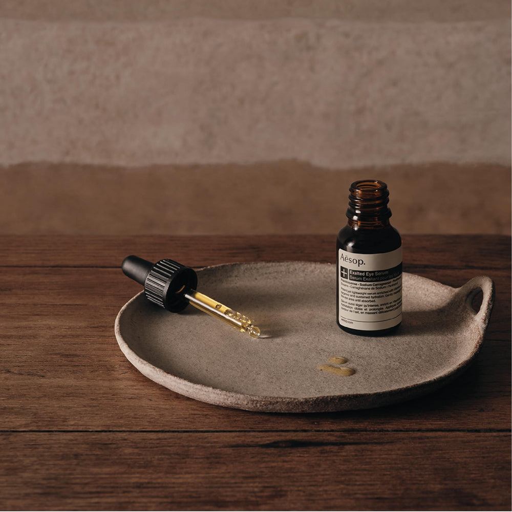 Drops dispense from Aesop Exalted Eye Serum onto the skin