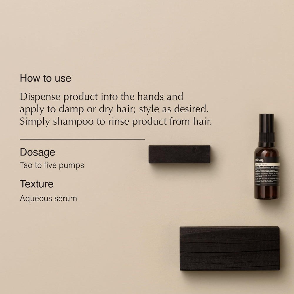 Dispensing Aesop Tame Hair Serum into hands for smoothing damp hair.