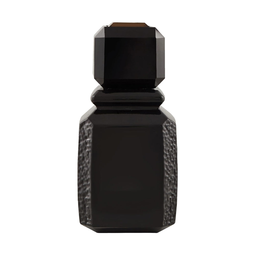 Ajmal Patchouli Wood closeup highlighting warm amber tones and textured glass for luxury appeal.