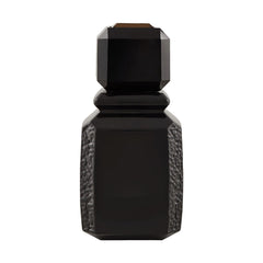 Ajmal Patchouli Wood closeup highlighting warm amber tones and textured glass for luxury appeal.