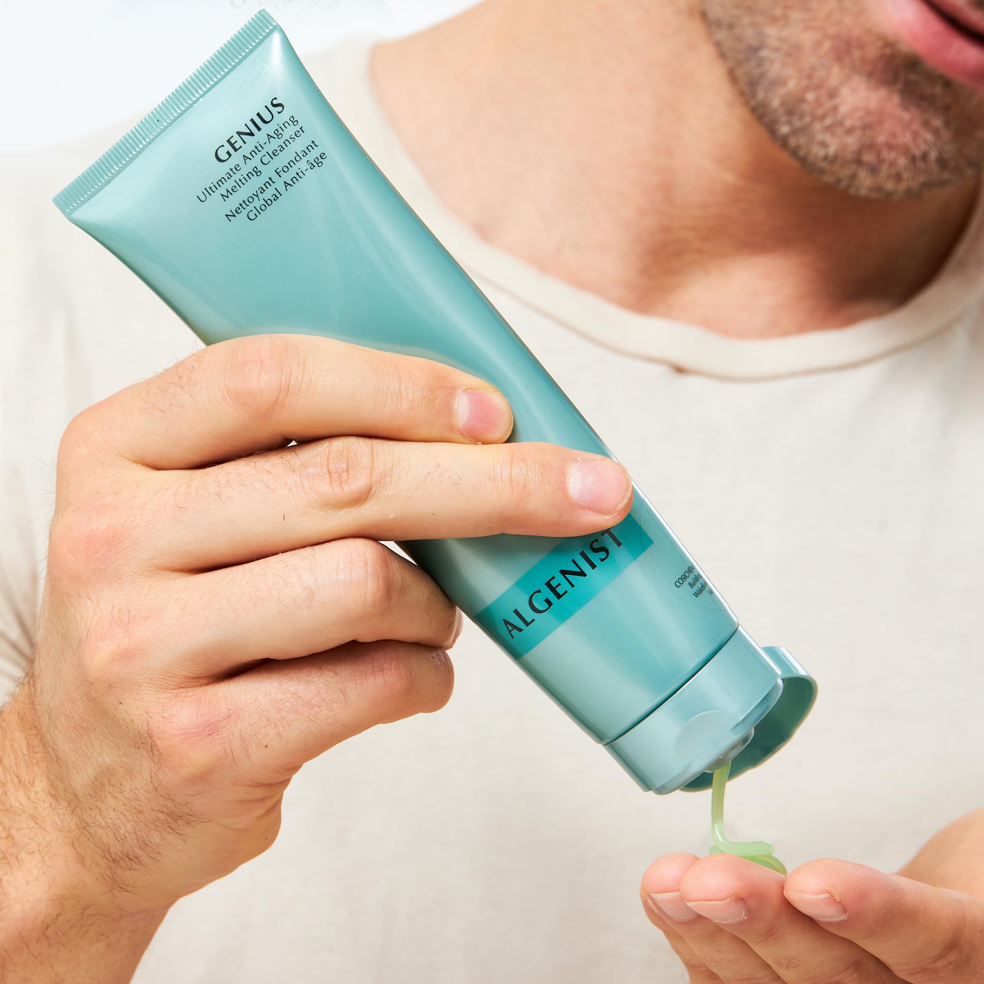 Algenist GENIUS cleansing milky emulsion art on water rinse demonstrates easy rinse-off.