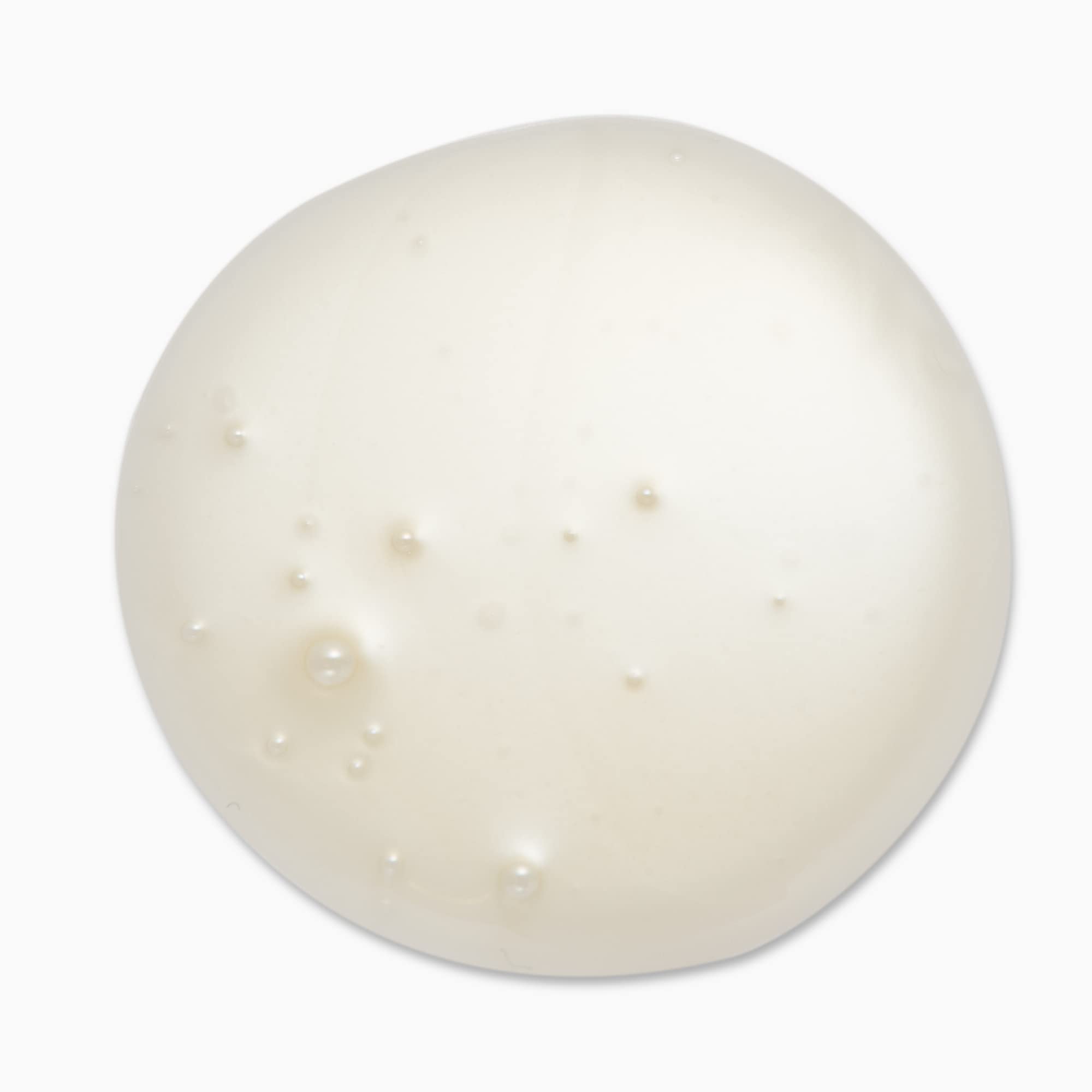 In-use shot shows rich cream texture dispensing from pump.
