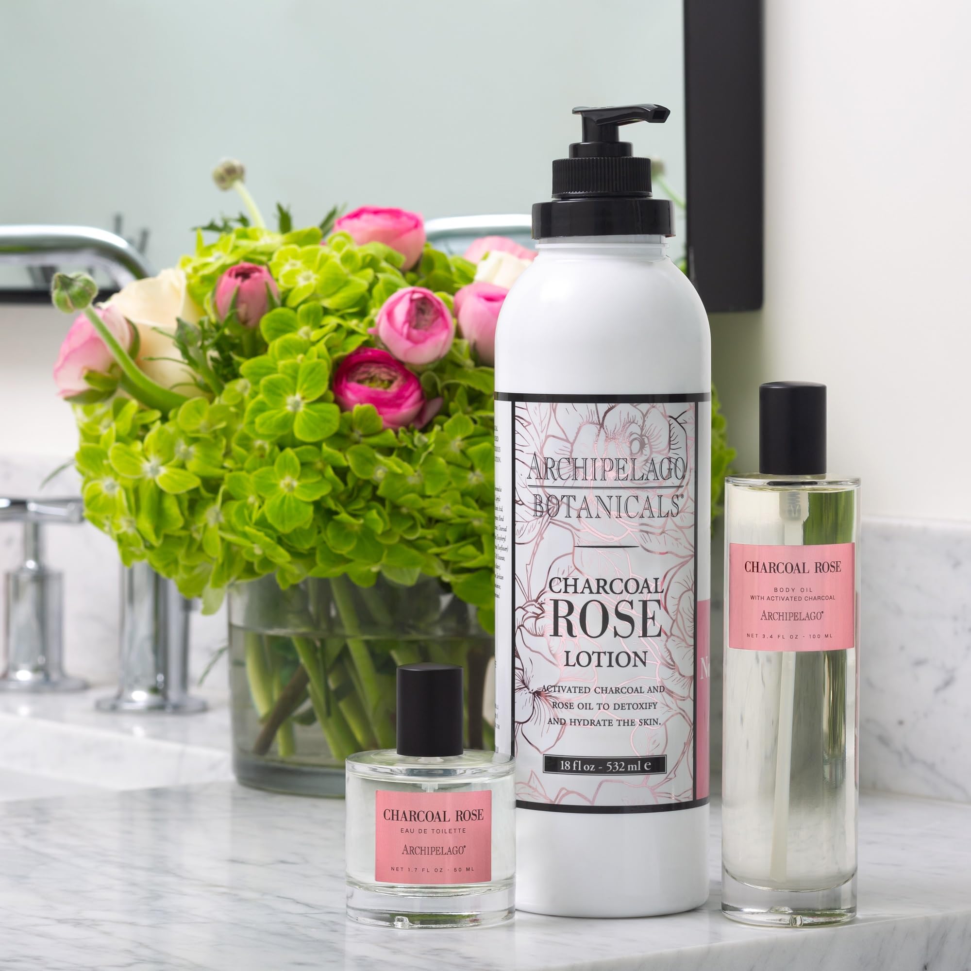 Hand applying Archipelago Charcoal Rose Lotion for soft, non-greasy skin