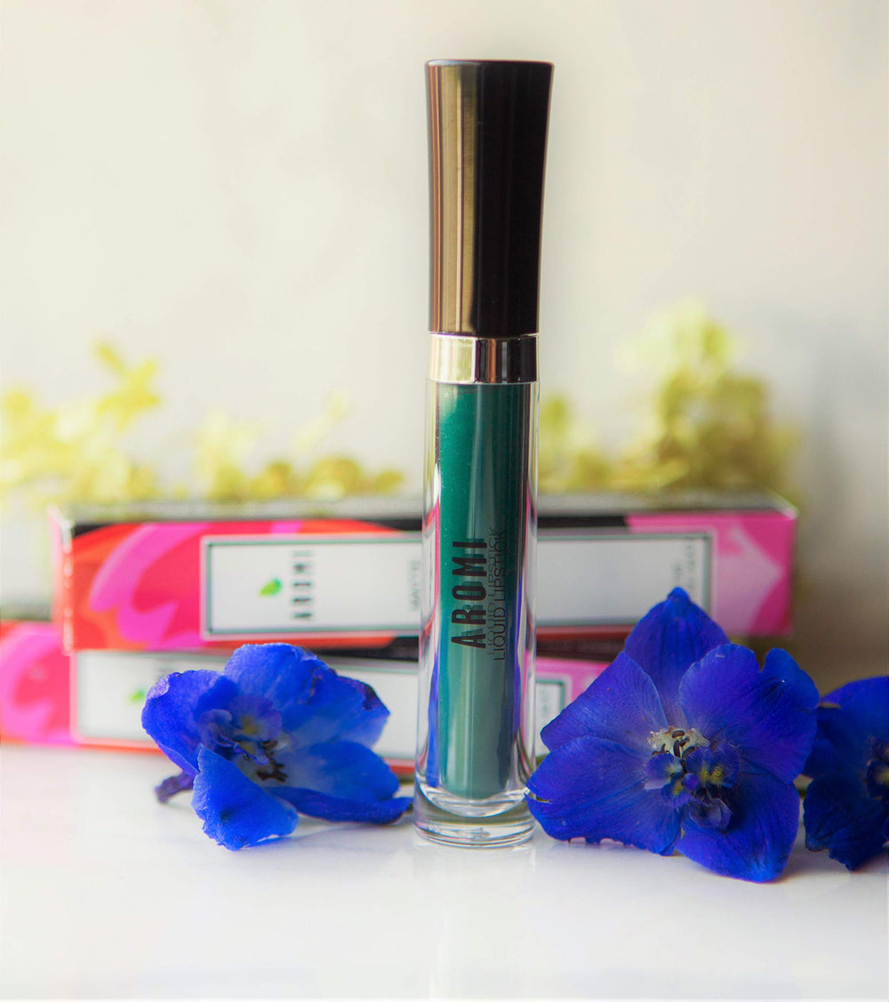 Aromi Emerald Green matte lipstick swatch shows vivid color with a velvety finish.