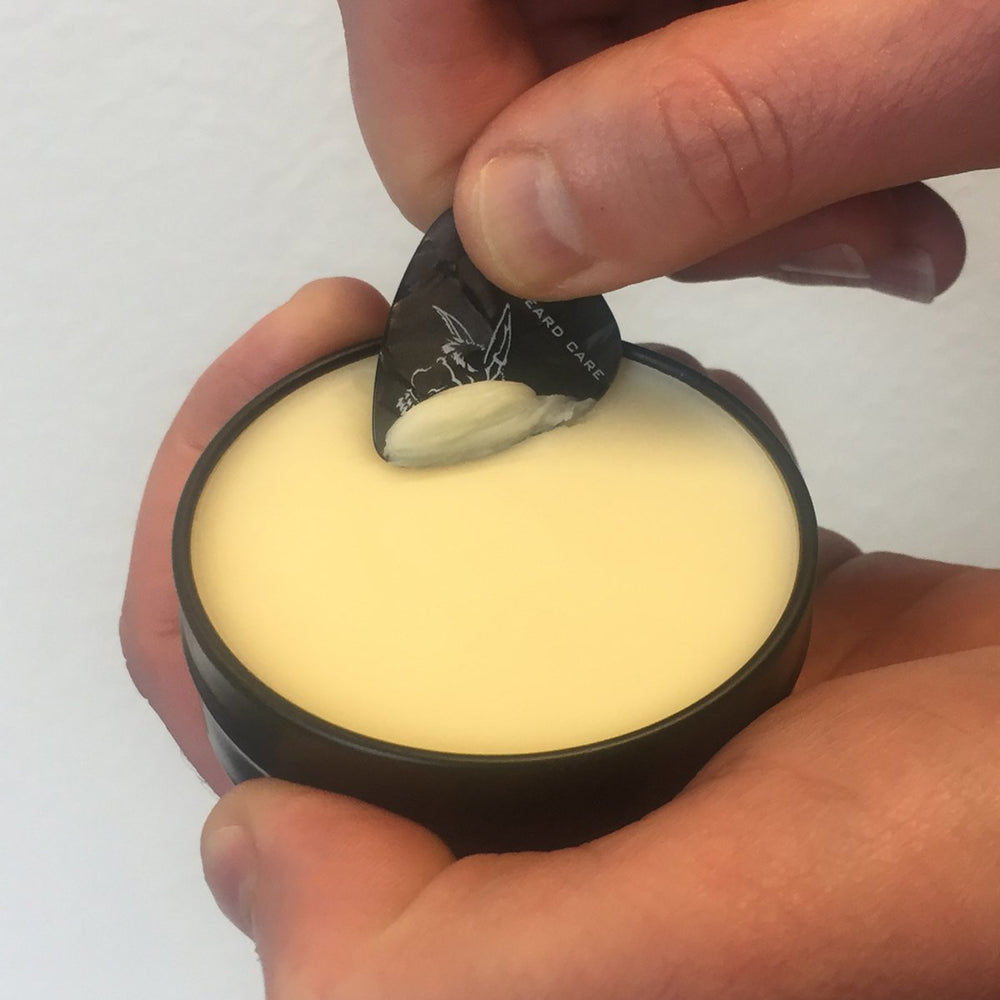 Natural ingredients label on Badass Beard Wax for conditioning and softness.