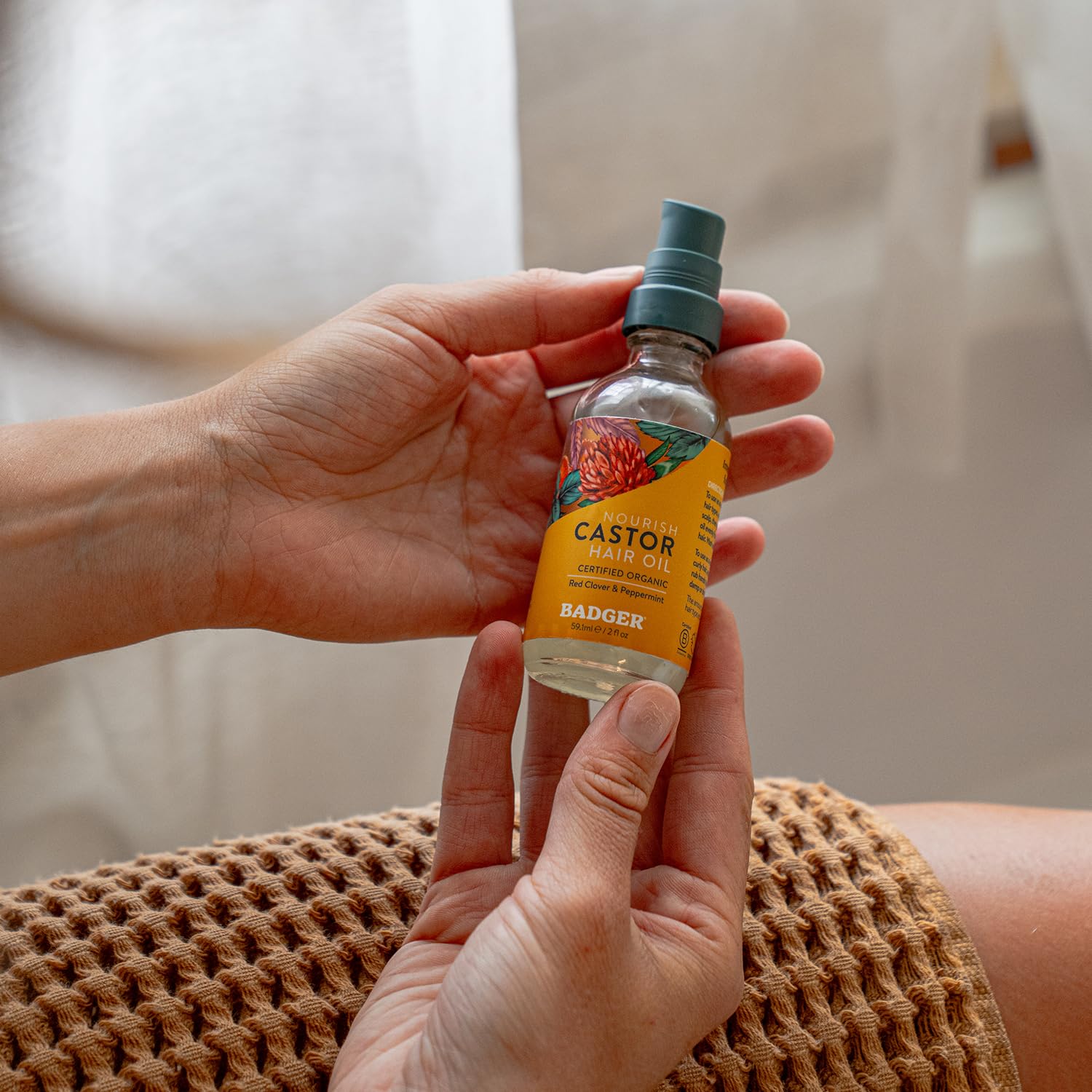 Badger hair oil application on hand demonstrates precise, targeted treatment.