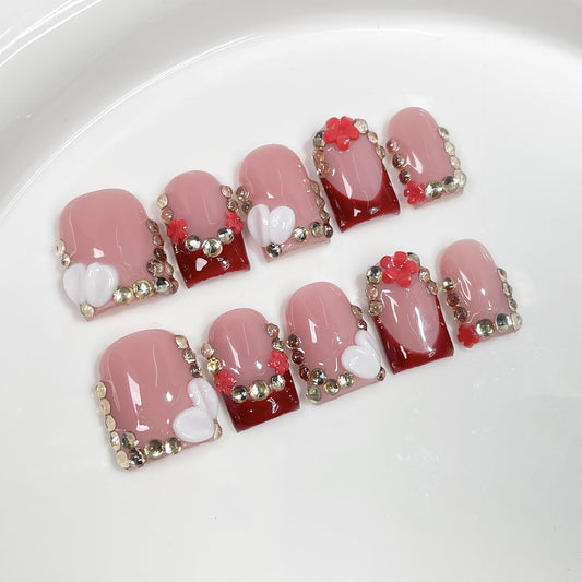 BRKYKGK French Tip nails with floral rhinestones for a chic look.