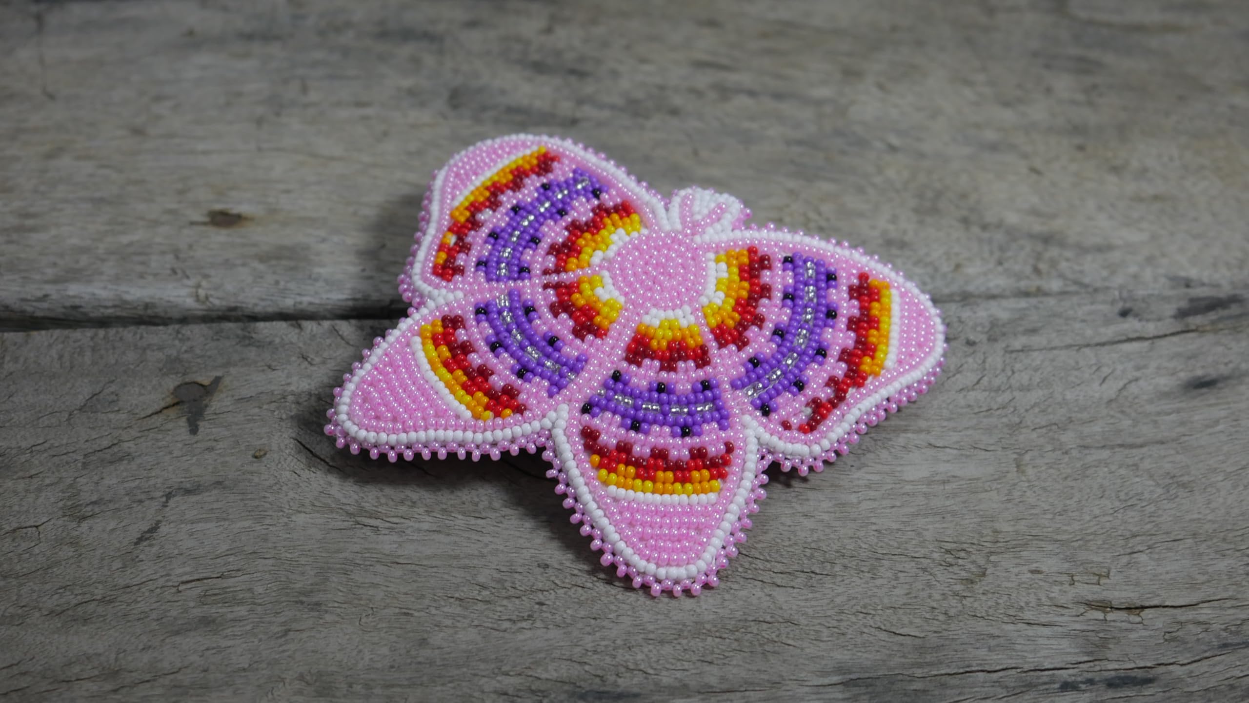 BuyBeaded beadwork close-up reveals tiny zirconia beads and multicolored patterns.
