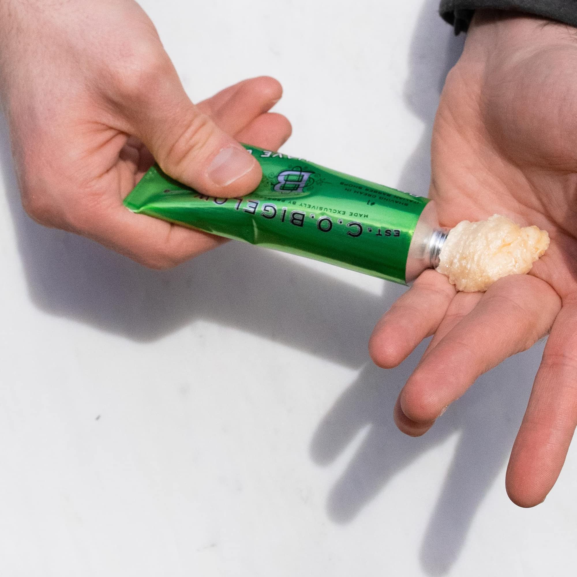 Hands holding travel-friendly shaving cream, ideal for gym bag.