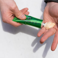 Hands holding travel-friendly shaving cream, ideal for gym bag.