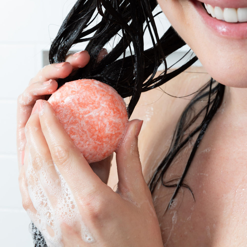 Community Goods Citrus Squeeze Shampoo Bar lathering on hair for refreshing, balanced cleanse.