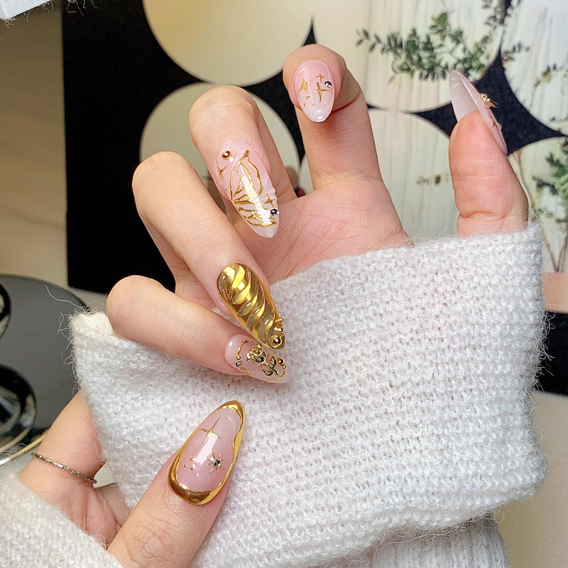 Close-up of CTTHNBD almond nails with gold bow design for events