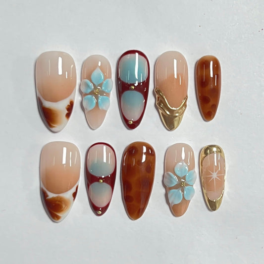CTTHNBD almond nails with flower accent and gold line for chic fall style