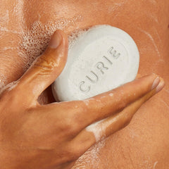 Curie bar lathering on wet skin during shower.