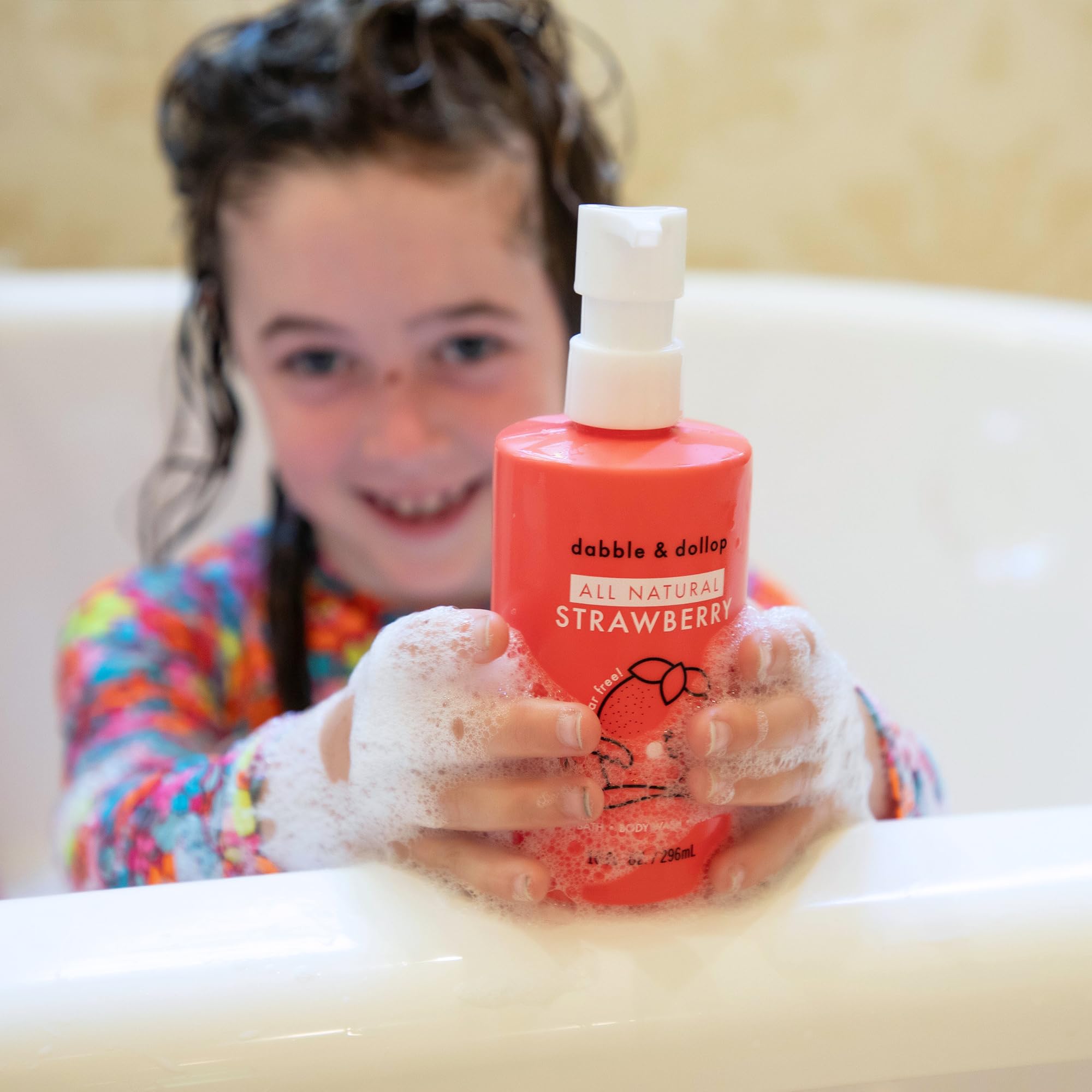 Pouring Dabble & Dollop strawberry 3-in-1 bottle for easy application.