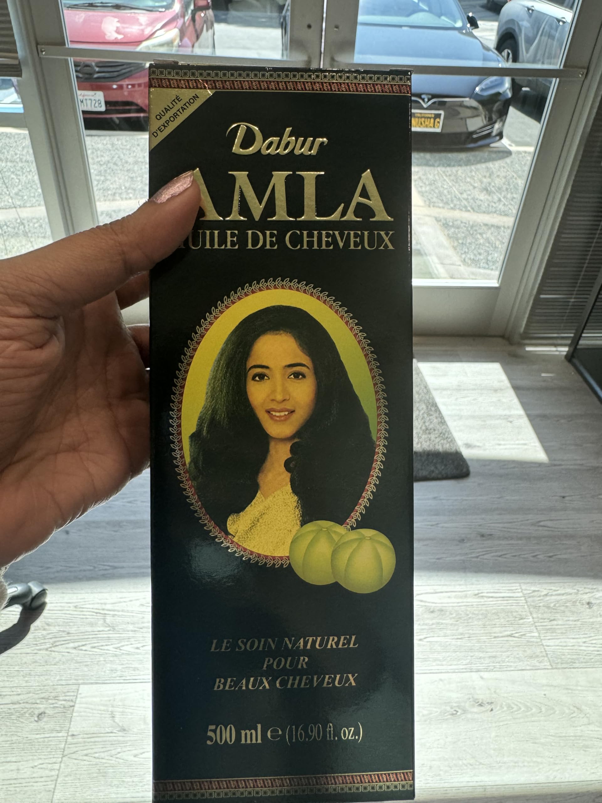 Dabur Amla Hair Oil application scene showing massaging hair.