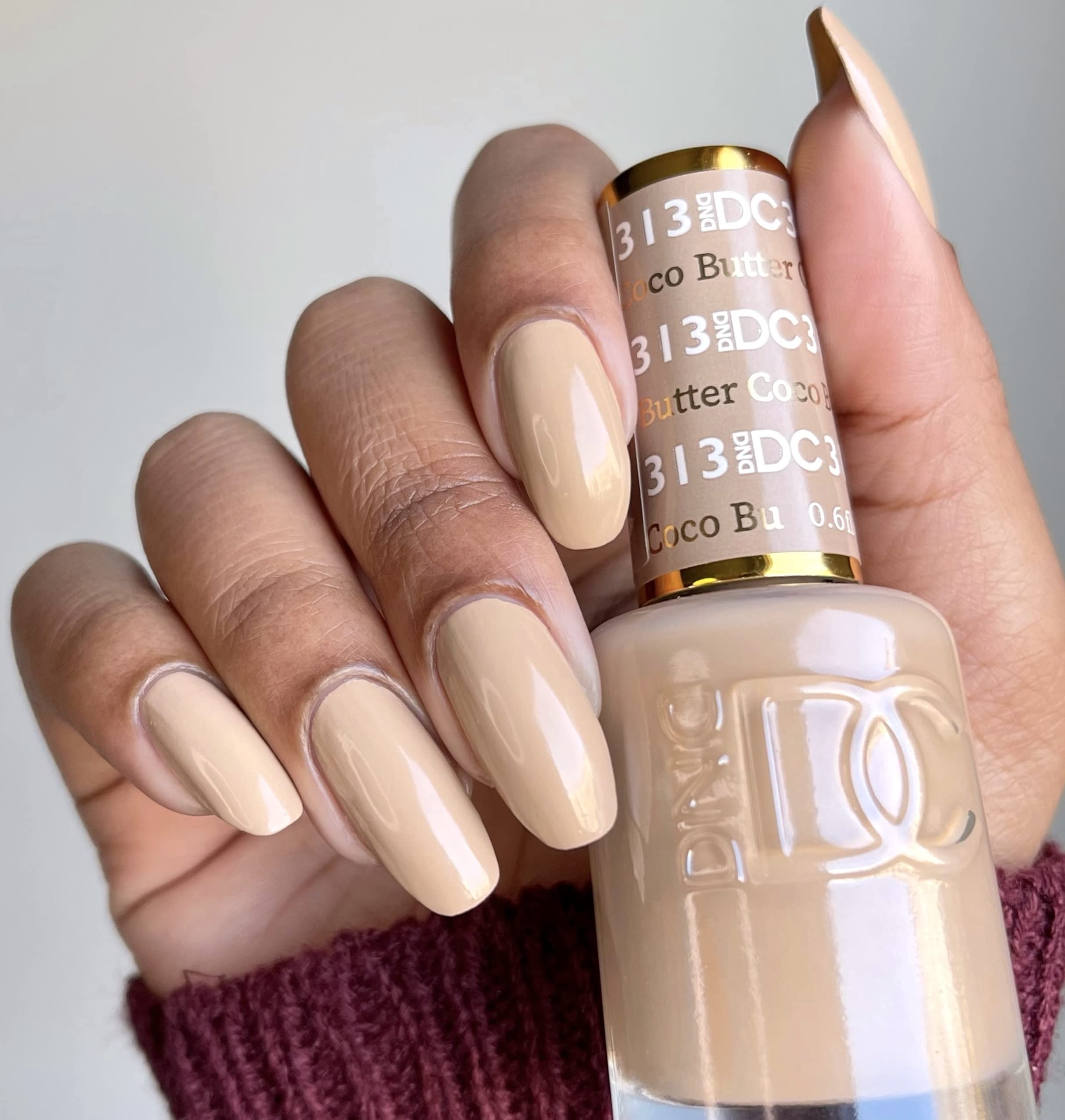 Daisy DND Coco Butter lacquer bottle matches the gel color for a cohesive look.