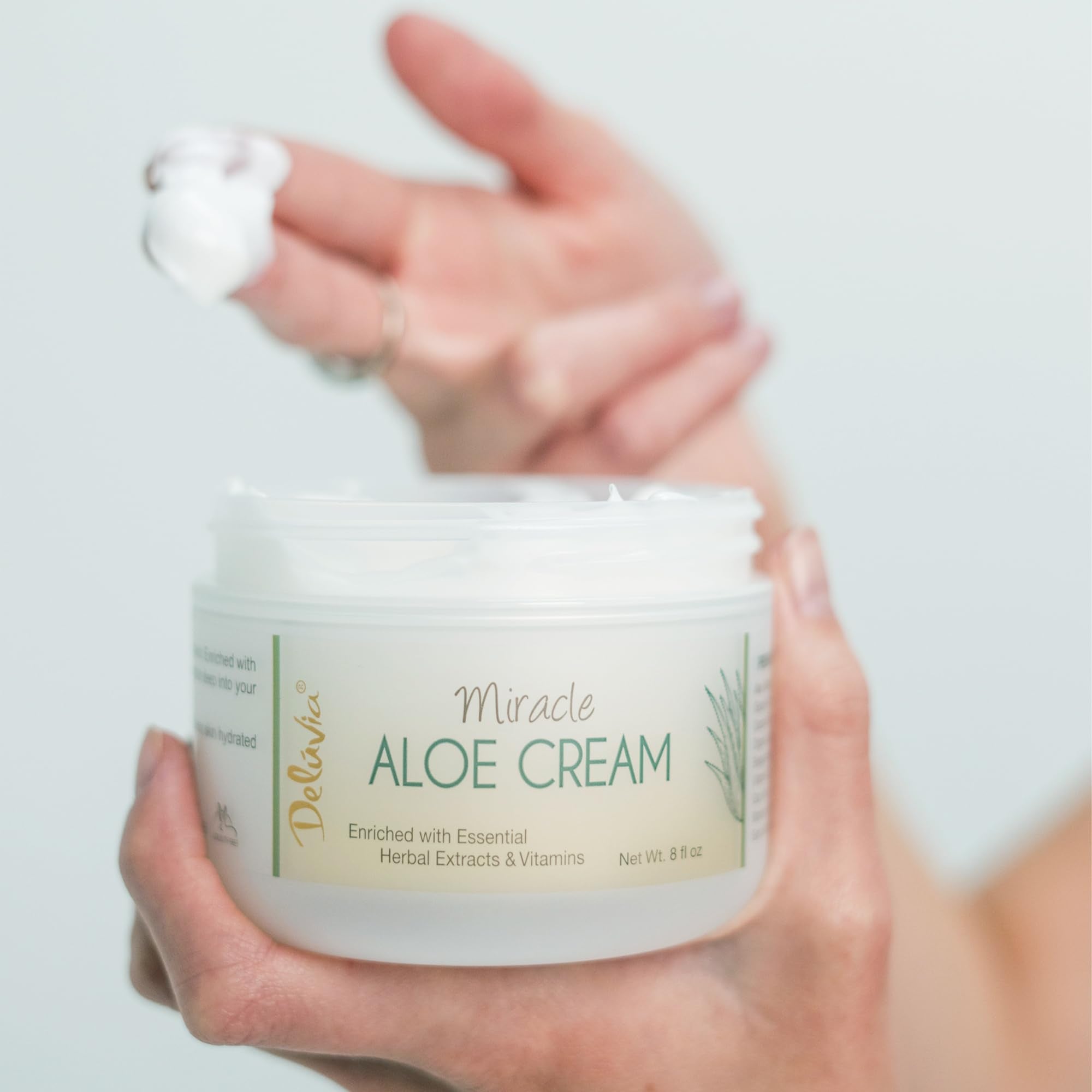 DELÚVIA Miracle Aloe Cream with organic aloe plant in the background.