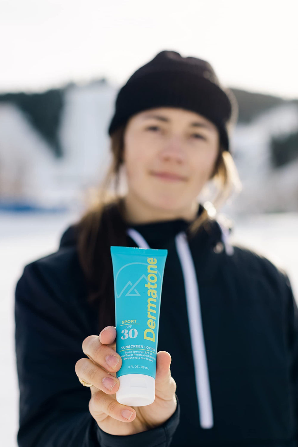 Applying Dermatone Sport Sunscreen Lotion SPF 30 on the arm during outdoor activity