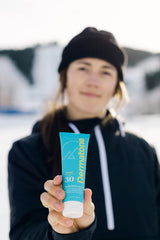 Applying Dermatone Sport Sunscreen Lotion SPF 30 on the arm during outdoor activity