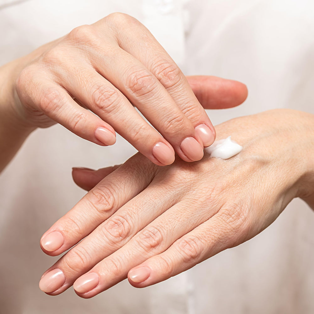 Hands applying the cream showing smooth absorption