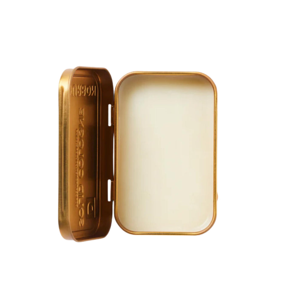Close-up of Duke Cannon Bourbon solid cologne tin for precise, mess-free application.