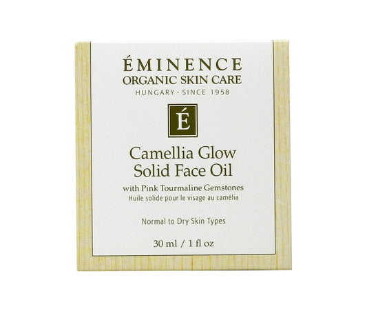 Eminence Camellia Glow solid oil in palm ready to melt onto skin.