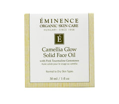 Eminence Camellia Glow solid oil in palm ready to melt onto skin.
