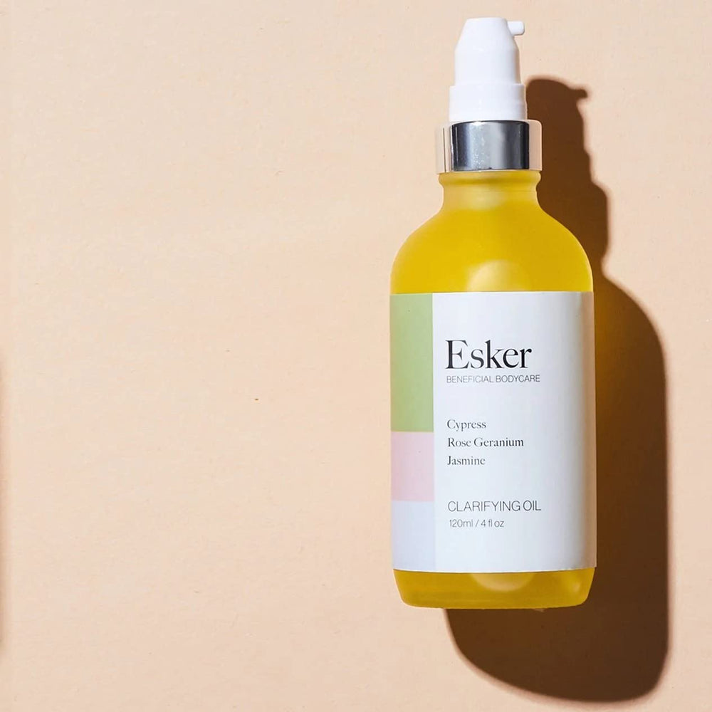 Person applying Esker Clarifying Oil to damp skin as part of daily routine.