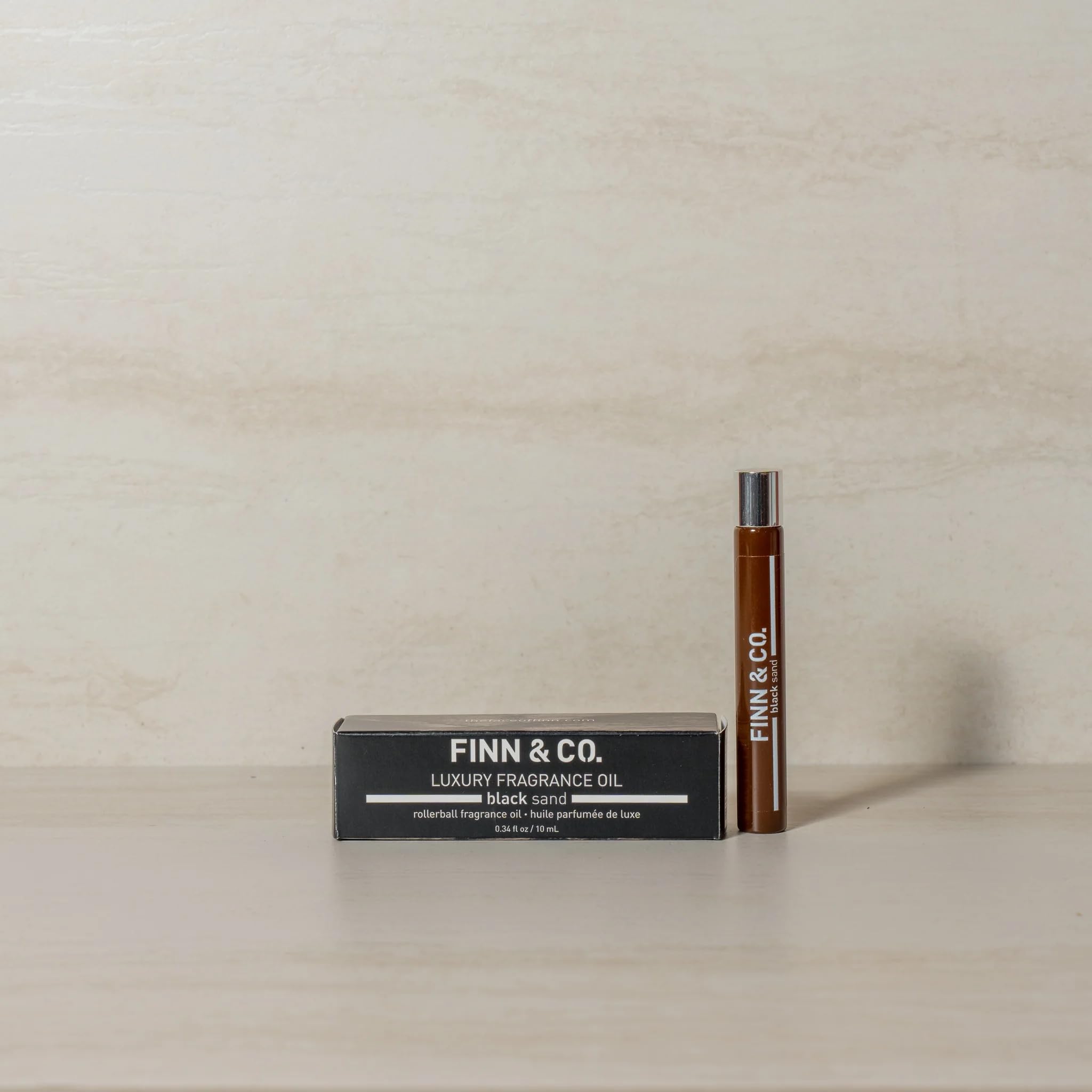 FINN & CO Black Sand bottle at dusk beach scene, warm sandalwood notes.
