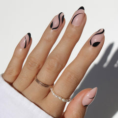 Glamnetic Ink Wave short almond nails with sheer base and glossy black swirls.