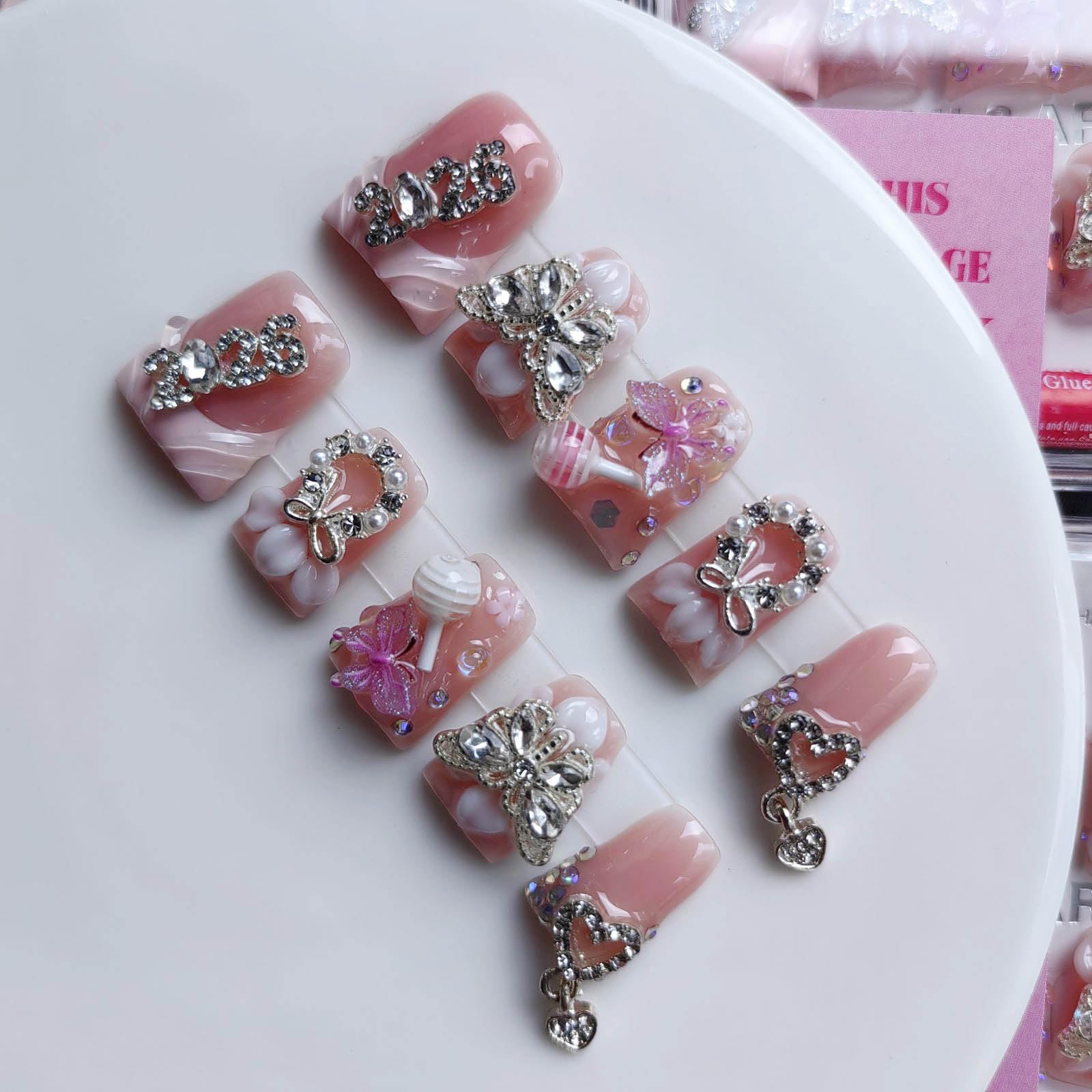 Gleamrain pink nails with butterfly embellishments for spring and Valentins Day styling
