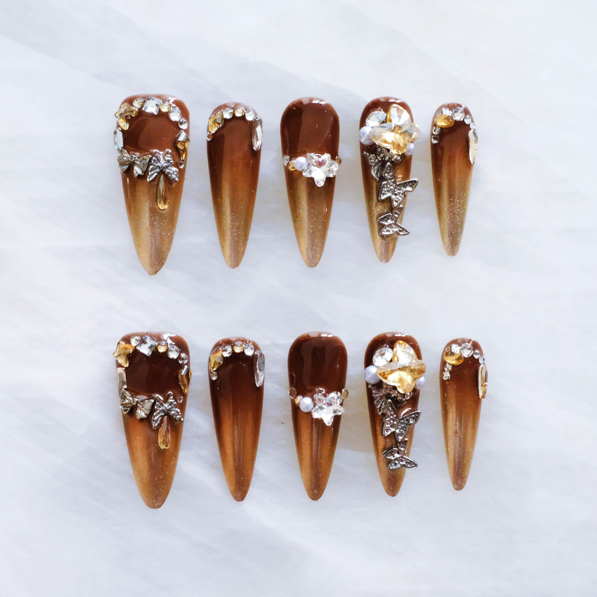 GLORS brown-to-gold ombre stiletto nails with 3D rhinestones for a dramatic look