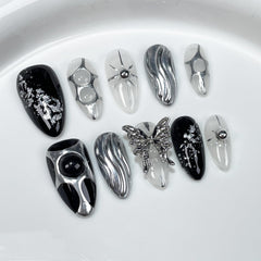 GLORS Gothic long almond nails with black and silver butterfly accent for bold evenings