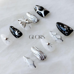 GLORS Gothic long almond nails with a metallic butterfly accent for whimsical glamour