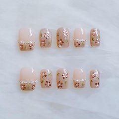 GLORS nude pink base nails with rose gold foil and pearl accents for weddings