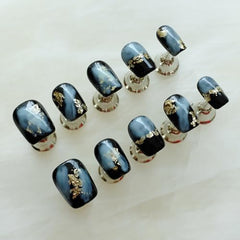 GLORS manicure-ready nails show bold marble pattern and luxe gold glitter highlights