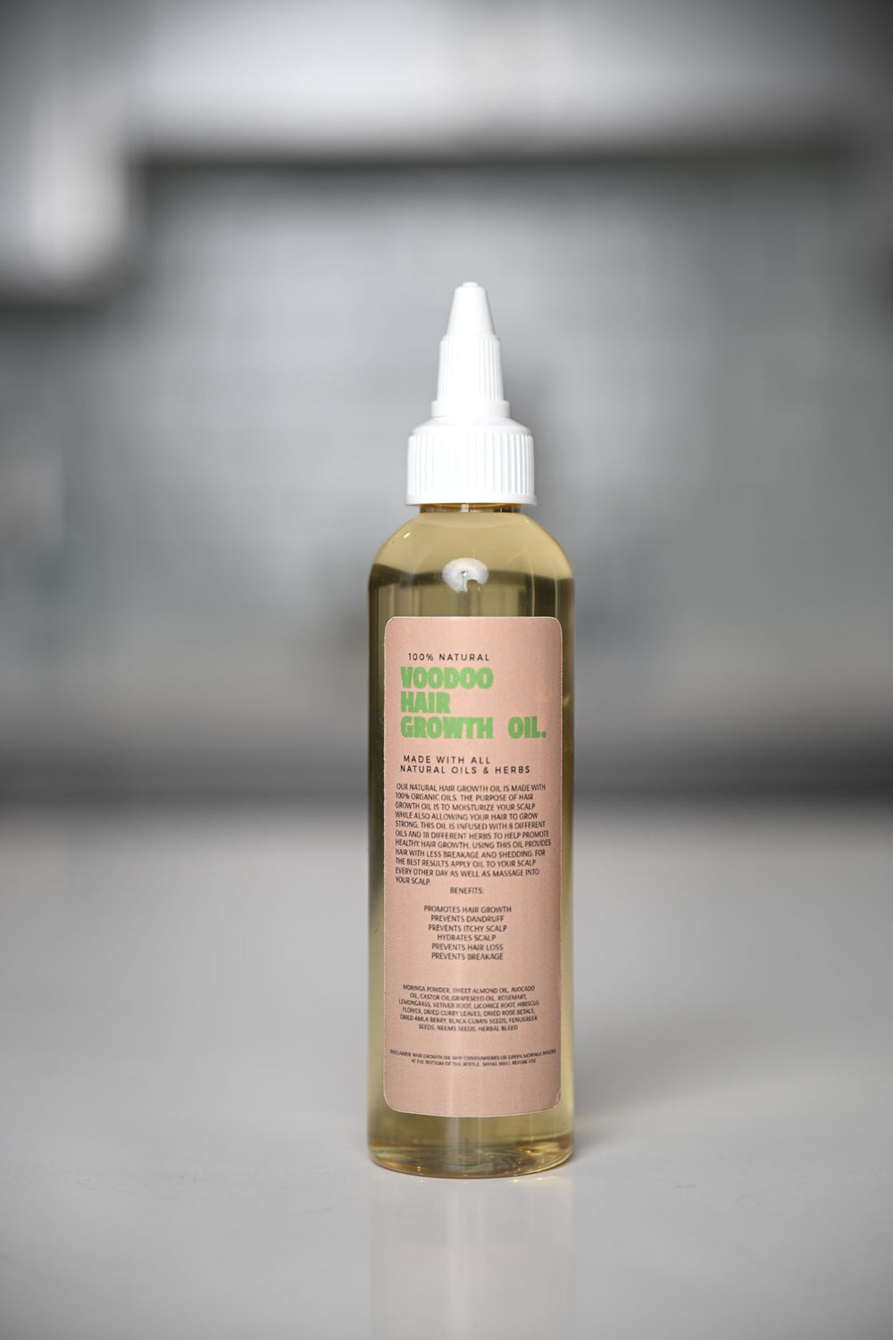 Glossed by Nae Voodoo Hair Growth Oil 4 oz bottle in shot.
