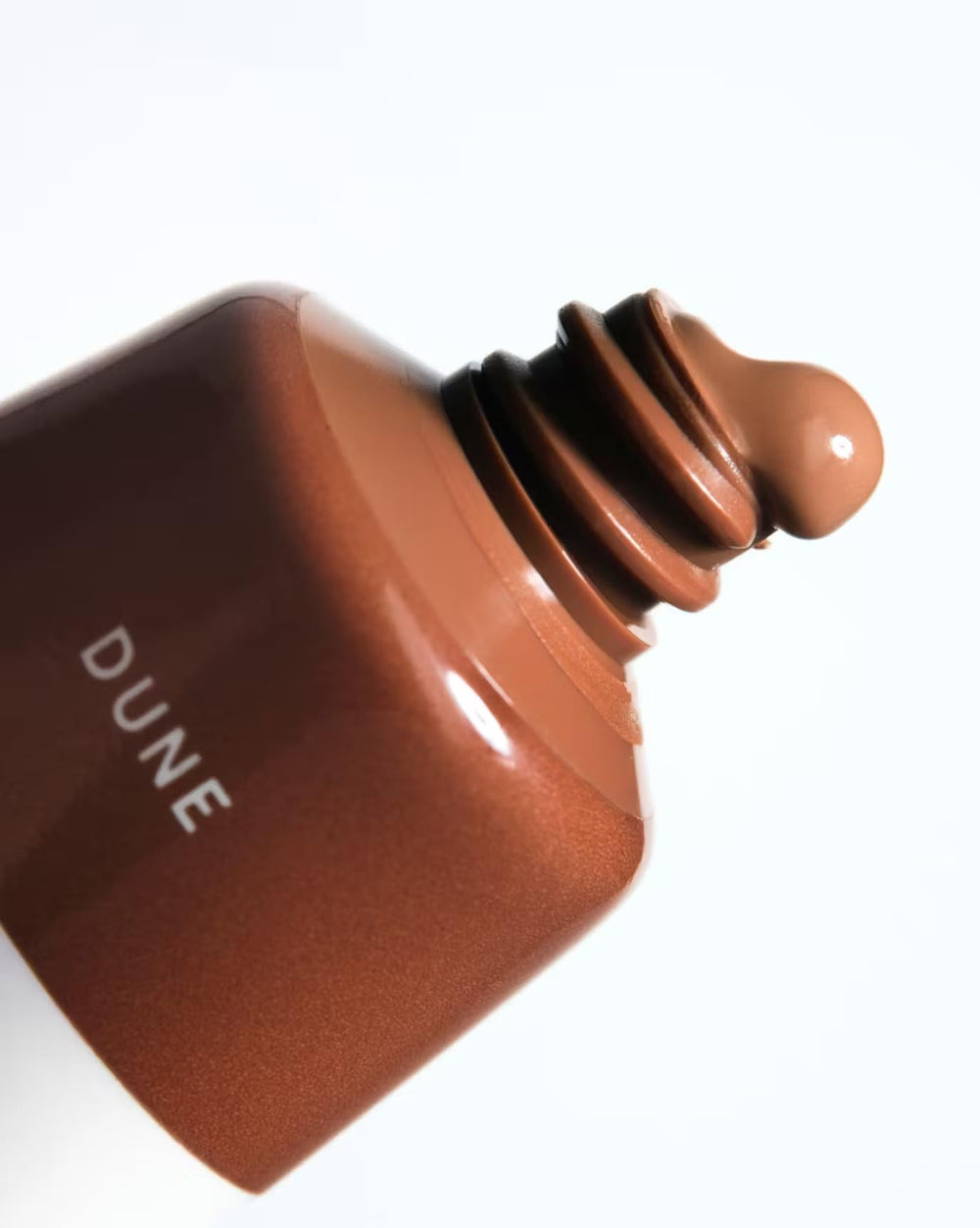 Glossier Cloud Paint Dune warm nude shade adding sun-kissed definition.