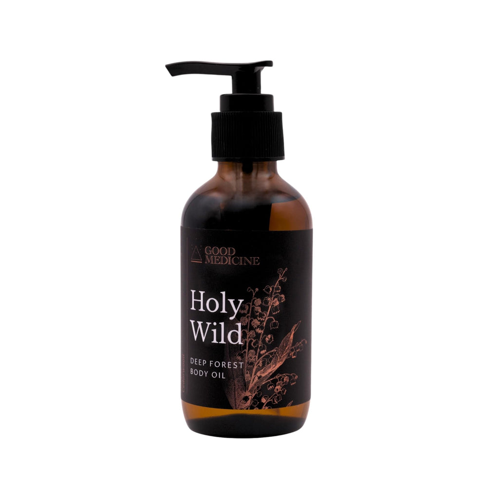 GOOD MEDICINE INTUITIVE SKINCARE Holy Wild Deep Forest Body Oil bottle in a forest setting hydrates skin.