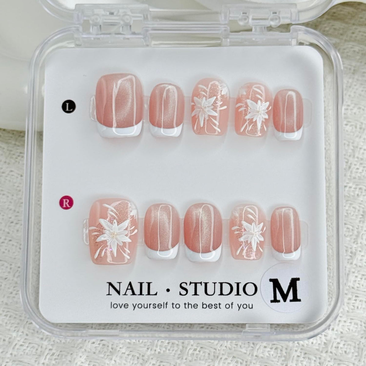 Handmade press-on nails: white French tips with flower designs for a polished look.